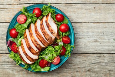 Kızarmış tavuk göğsü (fileto) lahana salatası ve kiraz domatesli. Kırsal arkaplanda üst görünüm