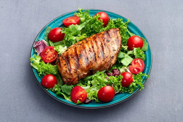 Kızarmış tavuk göğsü (fileto) lahana salatası ve kiraz domatesli. Kırsal arkaplanda üst görünüm