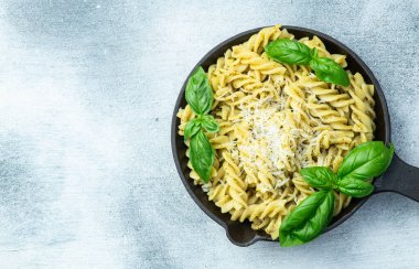 Fesleğen soslu makarna. İtalyan yemek fotoğrafçılığı. Kırsal arkaplanda üst görünüm