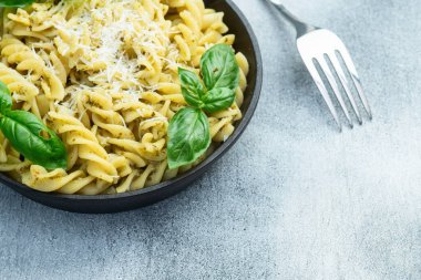 Fesleğen soslu makarna. İtalyan yemek fotoğrafçılığı. Kırsal arkaplanda üst görünüm
