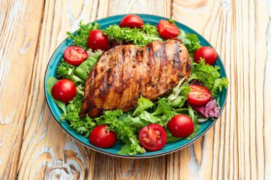 Kızarmış tavuk göğsü (fileto) lahana salatası ve kiraz domatesli. Kırsal arkaplanda üst görünüm