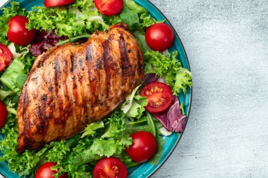 Kızarmış tavuk göğsü (fileto) lahana salatası ve kiraz domatesli. Kırsal arkaplanda üst görünüm