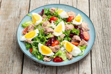 Yumurta ve domates fotoğraflı konserve ton balığı salatası. Kırsal arkaplanda üst görünüm