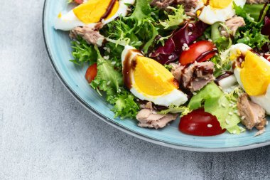 Yumurta ve domates fotoğraflı konserve ton balığı salatası. Kırsal arkaplanda üst görünüm