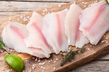 Çiğ tilapia fileto fotoğrafçılık. Kırsal arkaplanda üst görünüm