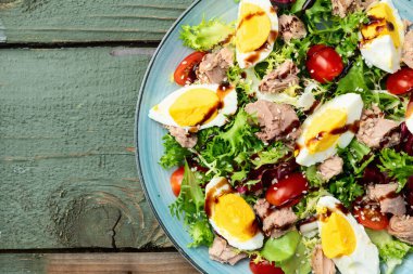 Yumurta ve domates fotoğraflı konserve ton balığı salatası. Kırsal arkaplanda üst görünüm