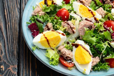 Yumurta ve domates fotoğraflı konserve ton balığı salatası. Kırsal arkaplanda üst görünüm