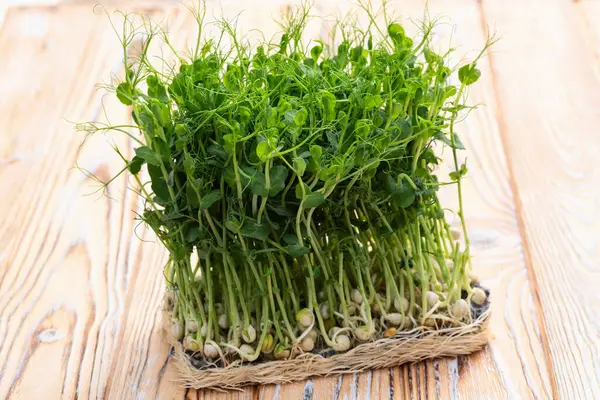 Organik mikroyeşil bezelye fotoğrafçılığı. Sağlıklı yiyecekler. Ahşap arkaplanda üst görünüm