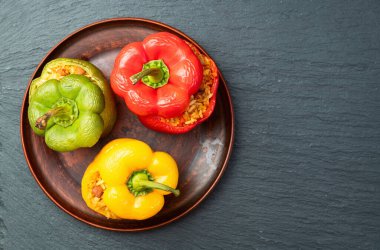 Pirinç, havuç ve etle doldurulmuş biber (paprika). Kırsal arkaplan fotoğrafçılığının üst görünümü