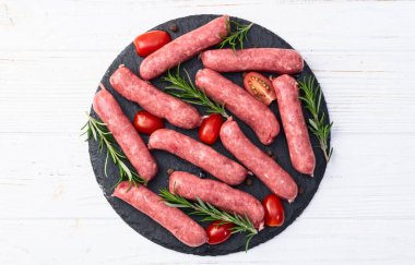 Biberiyeli çiğ et sosisi ve domates fotoğrafçılığı. Kırsal arkaplanda üst görünüm