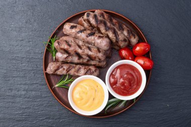 Biberiye soslu ızgara biftek ve domates fotoğrafçılığı. Kırsal arkaplanda üst görünüm