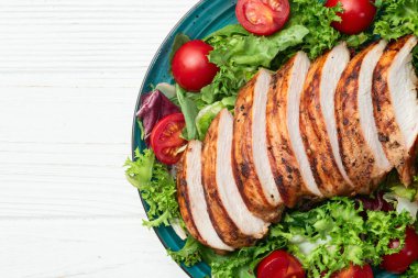 Kızarmış tavuk göğsü (fileto) lahana salatası ve kiraz domatesli. Kırsal arkaplanda üst görünüm