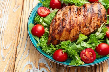 Kızarmış tavuk göğsü (fileto) lahana salatası ve kiraz domatesli. Kırsal arkaplanda üst görünüm