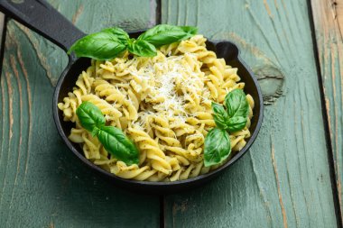 Fesleğen soslu makarna. İtalyan yemek fotoğrafçılığı. Kırsal arkaplanda üst görünüm