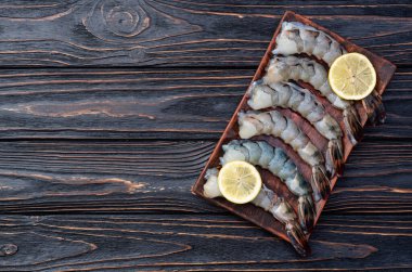 Çiğ büyük kaplan (kral) karidesleri temizler, soyarlar ve biçerdöverler. Kırsal arkaplanda üst görünüm