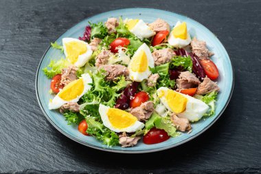 Yumurta ve domates fotoğraflı konserve ton balığı salatası. Kırsal arkaplanda üst görünüm