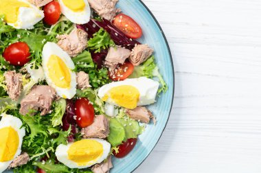 Yumurta ve domates fotoğraflı konserve ton balığı salatası. Kırsal arkaplanda üst görünüm