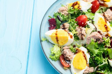 Yumurta ve domates fotoğraflı konserve ton balığı salatası. Kırsal arkaplanda üst görünüm