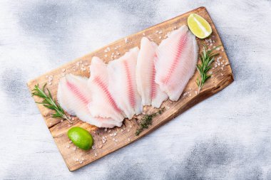 Çiğ tilapia fileto fotoğrafçılık. Kırsal arkaplanda üst görünüm