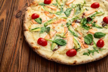 Avokado somon domatesli İtalyan pizzası ve mozzarella fotoğrafçılığı. Kırsal arkaplanda üst görünüm