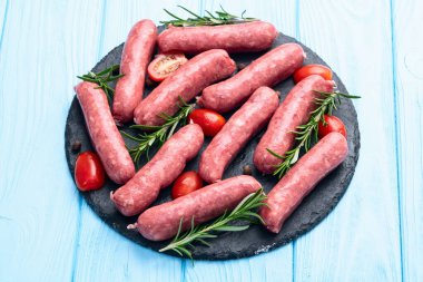 Biberiyeli çiğ et sosisi ve domates fotoğrafçılığı. Kırsal arkaplanda üst görünüm