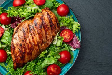 Kızarmış tavuk göğsü (fileto) lahana salatası ve kiraz domatesli. Kırsal arkaplanda üst görünüm