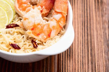 Tom karidesli leziz çorba hazır erişte ve limon fotoğrafçılığı. Asya yemekleri. Kırsal arkaplanda üst görünüm