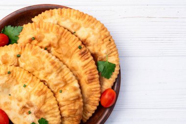 Atıştırmalık çizelgeler. Et fotoğrafçılığı yapan börekler. Kırsal arkaplanda üst görünüm