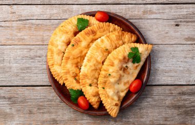 Atıştırmalık çizelgeler. Et fotoğrafçılığı yapan börekler. Kırsal arkaplanda üst görünüm