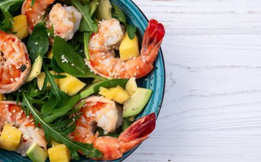 Kaplan karidesli salata, avokado ve mango. Kırsal arkaplanda üst görünüm