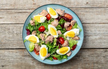 Yumurta ve domates fotoğraflı konserve ton balığı salatası. Kırsal arkaplanda üst görünüm