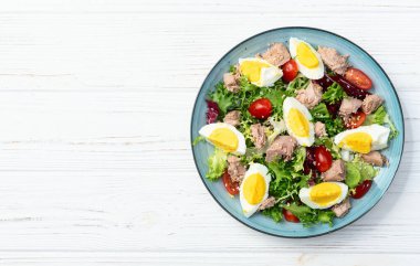 Yumurta ve domates fotoğraflı konserve ton balığı salatası. Kırsal arkaplanda üst görünüm