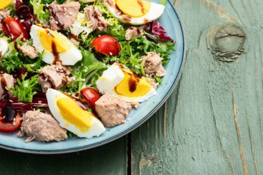 Yumurta ve domates fotoğraflı konserve ton balığı salatası. Kırsal arkaplanda üst görünüm