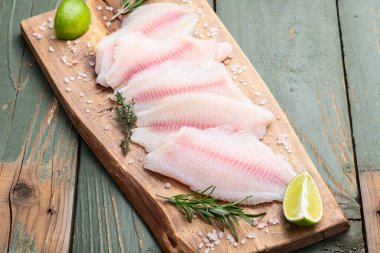 Çiğ tilapia fileto fotoğrafçılık. Kırsal arkaplanda üst görünüm