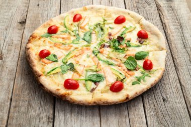 Avokado somon domatesli İtalyan pizzası ve mozzarella fotoğrafçılığı. Kırsal arkaplanda üst görünüm