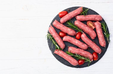 Biberiyeli çiğ et sosisi ve domates fotoğrafçılığı. Kırsal arkaplanda üst görünüm