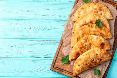 Atıştırmalık çizelgeler. Et fotoğrafçılığı yapan börekler. Kırsal arkaplanda üst görünüm