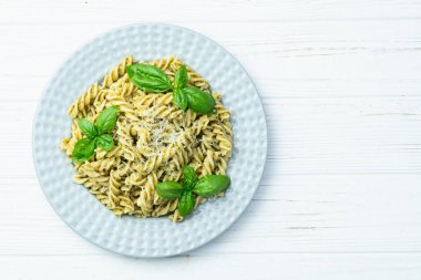 Fesleğen soslu makarna. İtalyan yemek fotoğrafçılığı. Kırsal arkaplanda üst görünüm