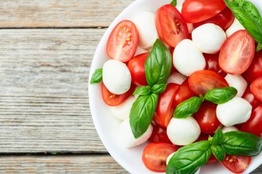 Fesleğen yaprakları, kiraz domatesleri ve mozzarella peyniri. Kase yemek fotoğrafçılığında. Üst görünüm