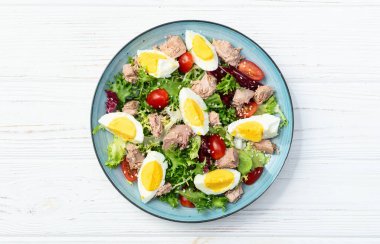 Yumurta ve domates fotoğraflı konserve ton balığı salatası. Kırsal arkaplanda üst görünüm