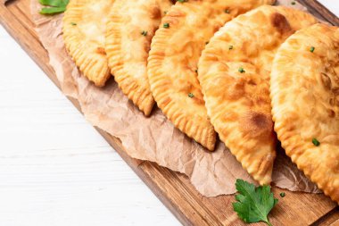 Atıştırmalık çizelgeler. Et fotoğrafçılığı yapan börekler. Kırsal arkaplanda üst görünüm