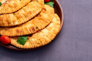 Atıştırmalık çizelgeler. Et fotoğrafçılığı yapan börekler. Kırsal arkaplanda üst görünüm