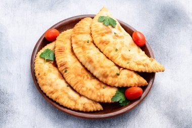 Atıştırmalık çizelgeler. Et fotoğrafçılığı yapan börekler. Kırsal arkaplanda üst görünüm