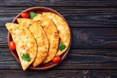 Atıştırmalık çizelgeler. Et fotoğrafçılığı yapan börekler. Kırsal arkaplanda üst görünüm