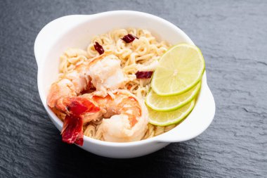 Tom karidesli leziz çorba hazır erişte ve limon fotoğrafçılığı. Asya yemekleri. Kırsal arkaplanda üst görünüm