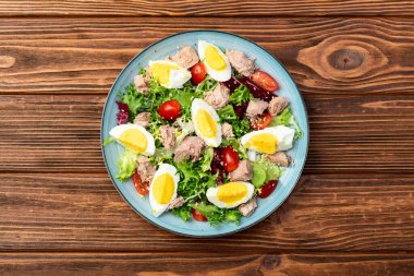 Yumurta ve domates fotoğraflı konserve ton balığı salatası. Kırsal arkaplanda üst görünüm