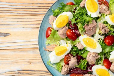 Yumurta ve domates fotoğraflı konserve ton balığı salatası. Kırsal arkaplanda üst görünüm