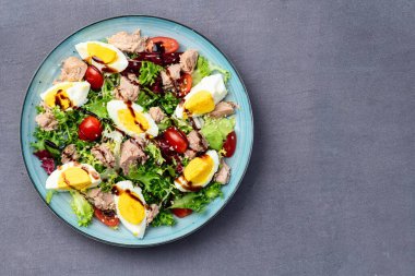 Yumurta ve domates fotoğraflı konserve ton balığı salatası. Kırsal arkaplanda üst görünüm