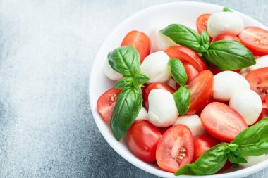 Fesleğen yaprakları, kiraz domatesleri ve mozzarella peyniri. Kase yemek fotoğrafçılığında. Üst görünüm