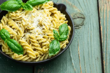 Fesleğen soslu makarna. İtalyan yemek fotoğrafçılığı. Kırsal arkaplanda üst görünüm